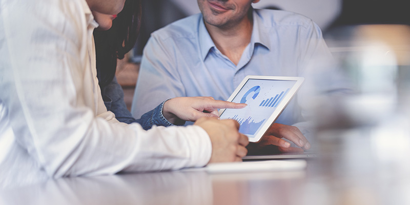 People lookng at charts and reports on a tablet